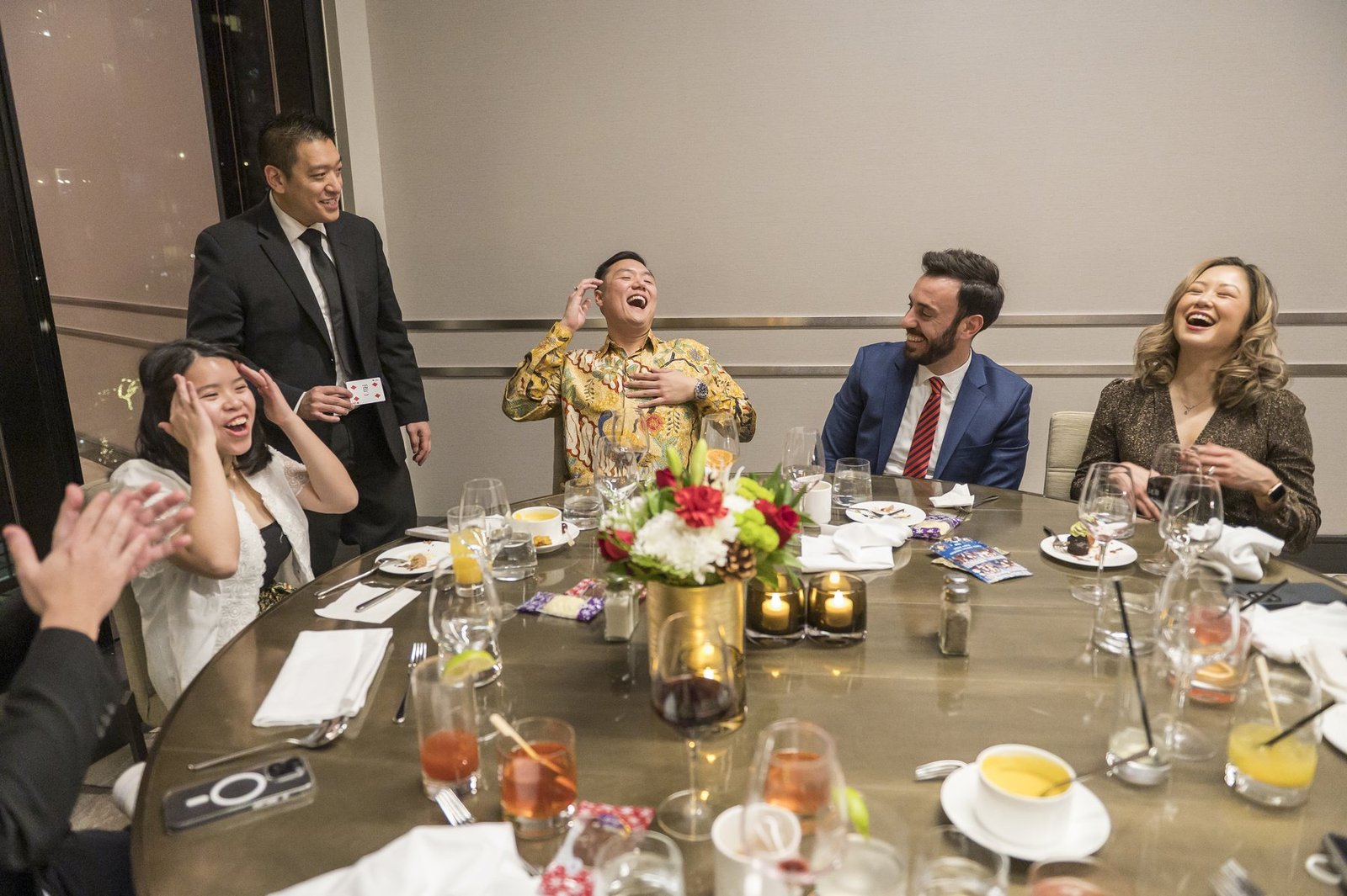 Corporate guests laughing during an interactive magic moment