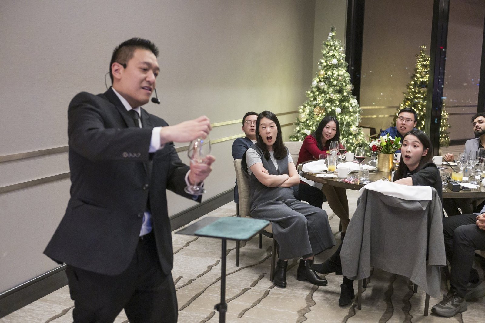 John Ha performing close-up magic for guests during an upscale Vancouver company dinner