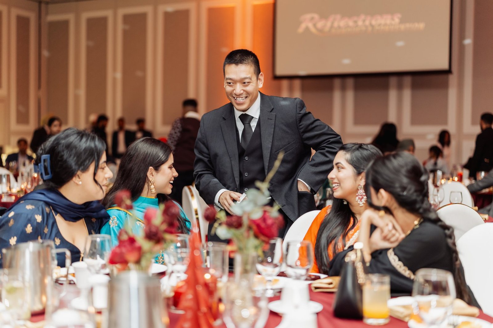 John Ha performing close-up magic for guests gathered at a Vancouver fundraiser table