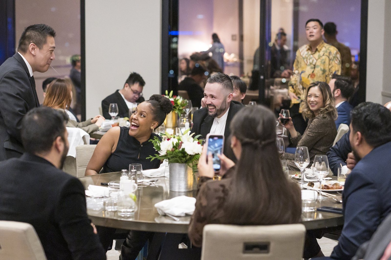John Ha performing close-up magic for surprised guests between formal moments at a Vancouver event