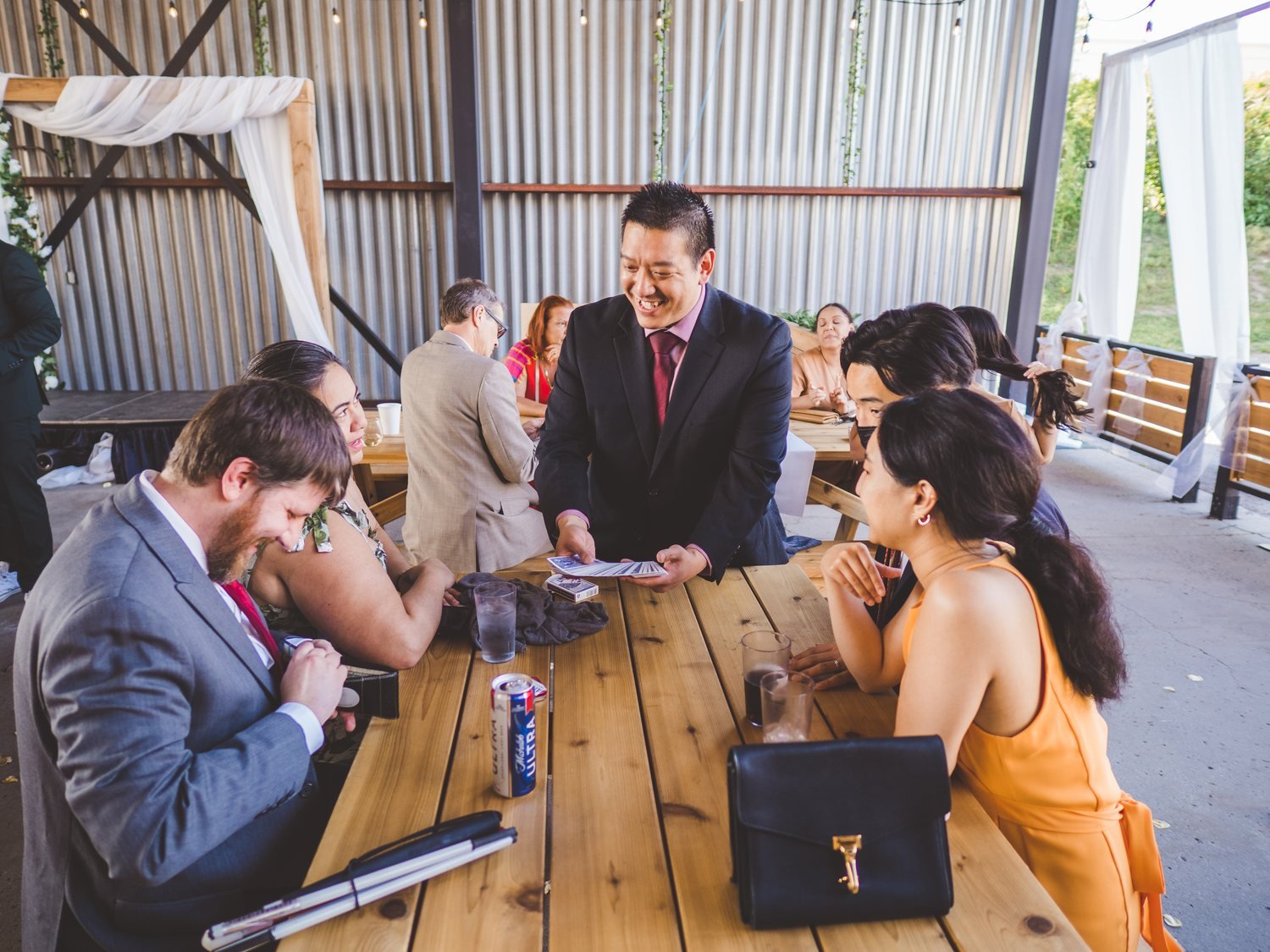 Guests smiling during close-up magic at a table